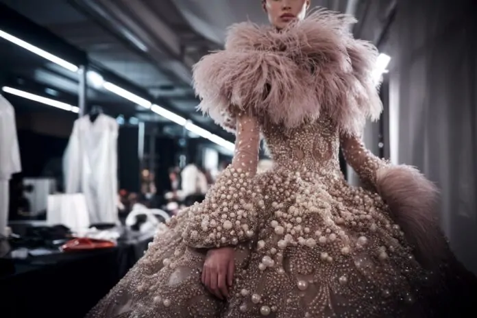 Couture perlée et plumes sur podium Mannequin haute couture portant une robe perlée et plumée à Paris